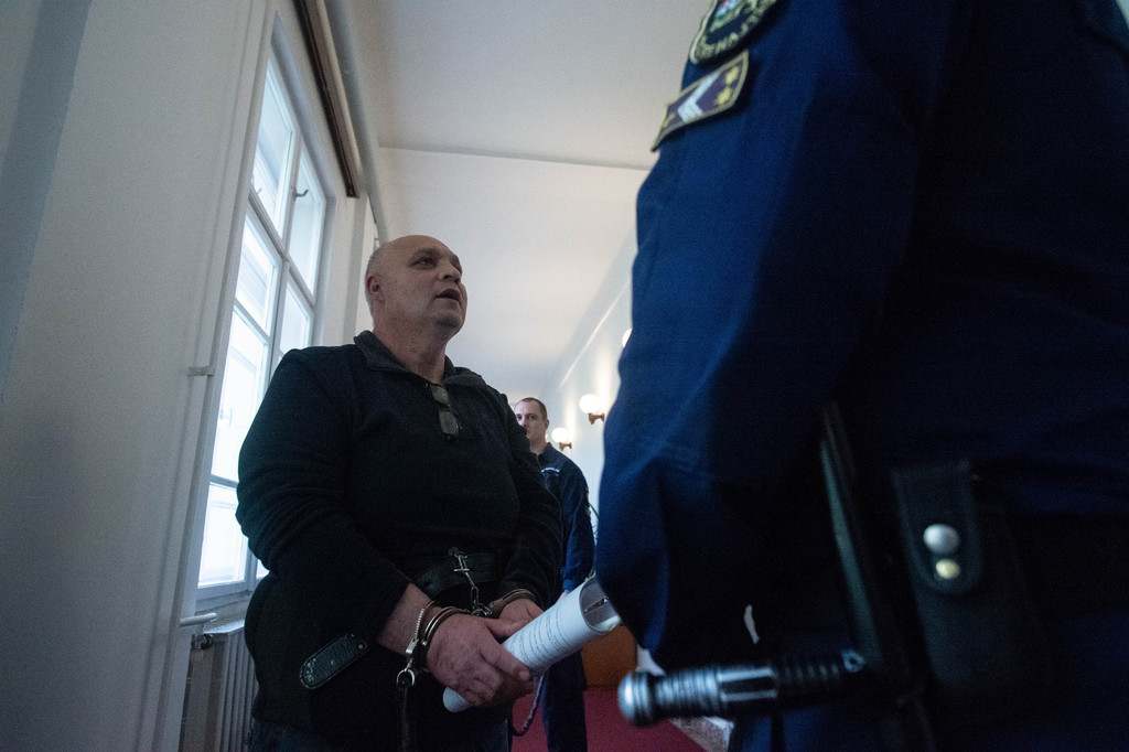 A tárgyalásra kísérik az elsőrendű vádlottat - Fotó: Röhrig Dániel