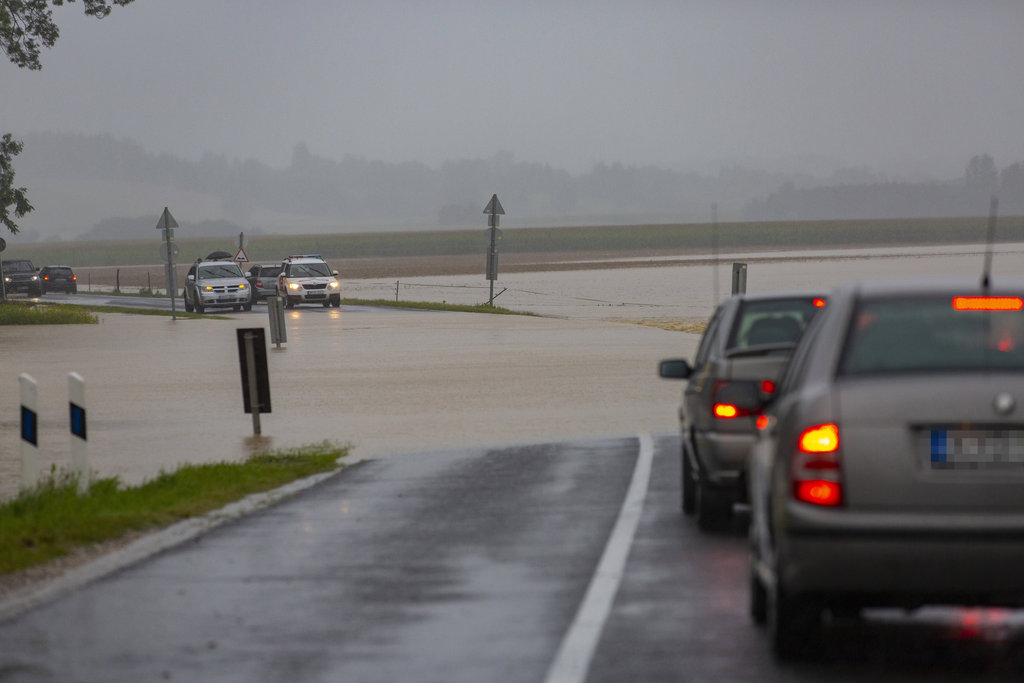 A katasztrófavédelm gépjárműve és egy terepjáró halad a nagy esőzés miatt vízzel elárasztott Csurgót és Gyékényest összekötő úton, a Somogy megyei Porrogszentkirály közelében 2020. július 25-én. A másik fotón autók állnak ugyanott. MTI/Varga György (2 / 1. kép)